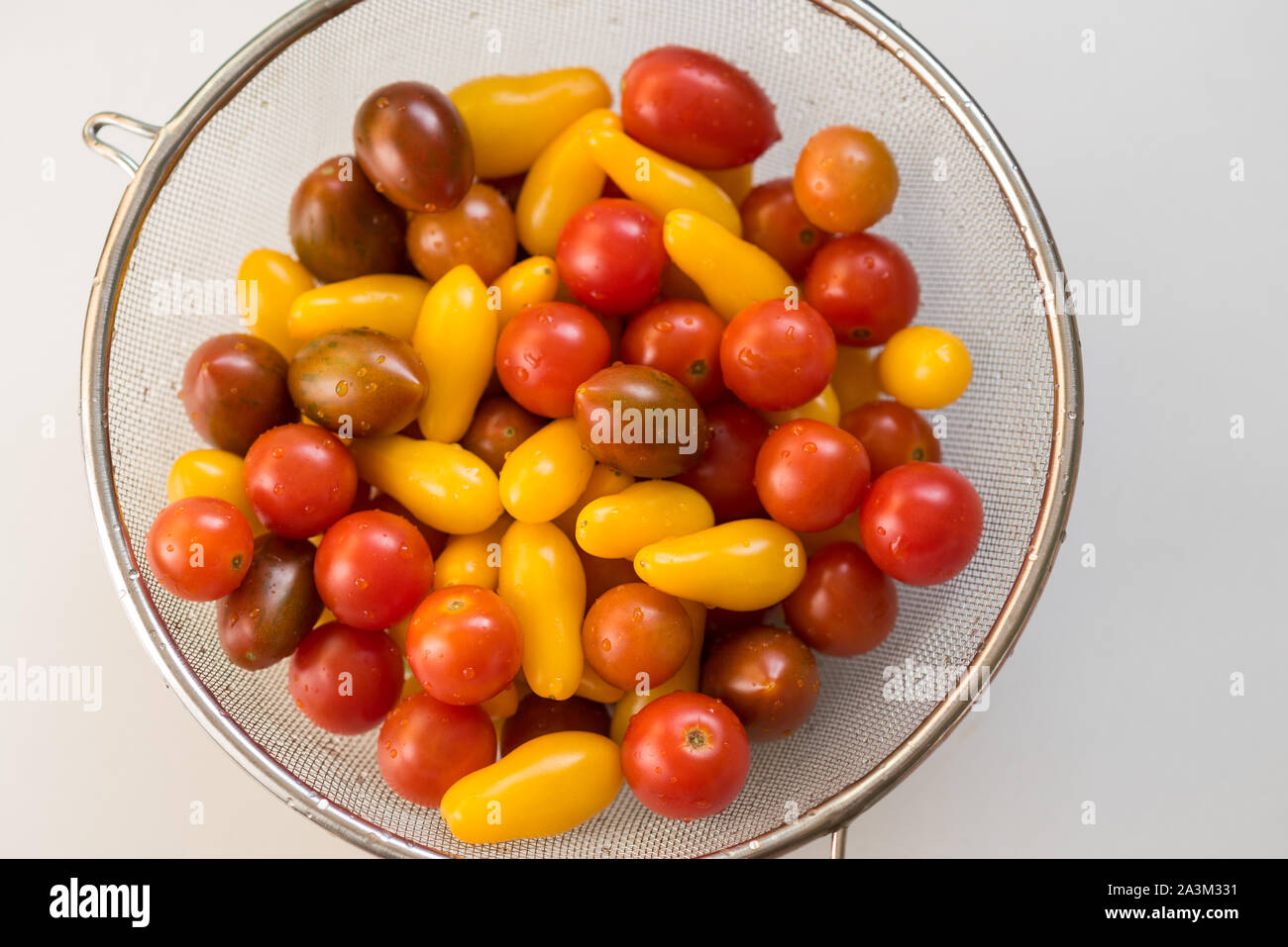 Propre, frais, tomates cerises colorés lavés dans une passoire. Gouttes  d'eau sur les légumes. Important de laver les légumes avant de les manger  concept Photo Stock - Alamy
