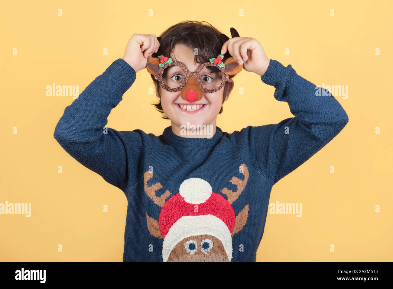 Joyeux Noël.Funny enfant dans un costume de noël Renne Rudolph sur fond jaune Banque D'Images