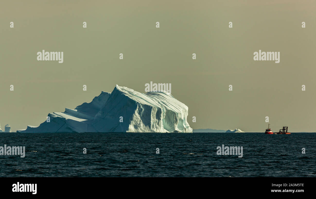 Un bateau de pêche rouge près des icebergs dans la baie de Disco (Groenland) en été Banque D'Images