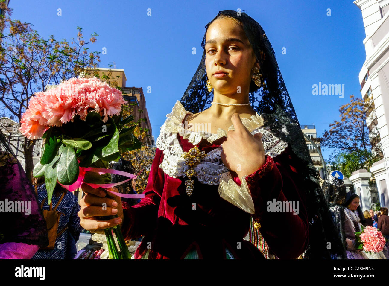 Jeune fille avec des fleurs roses pour Vierge Marie, Las Fallas Valencia Espagne Banque D'Images
