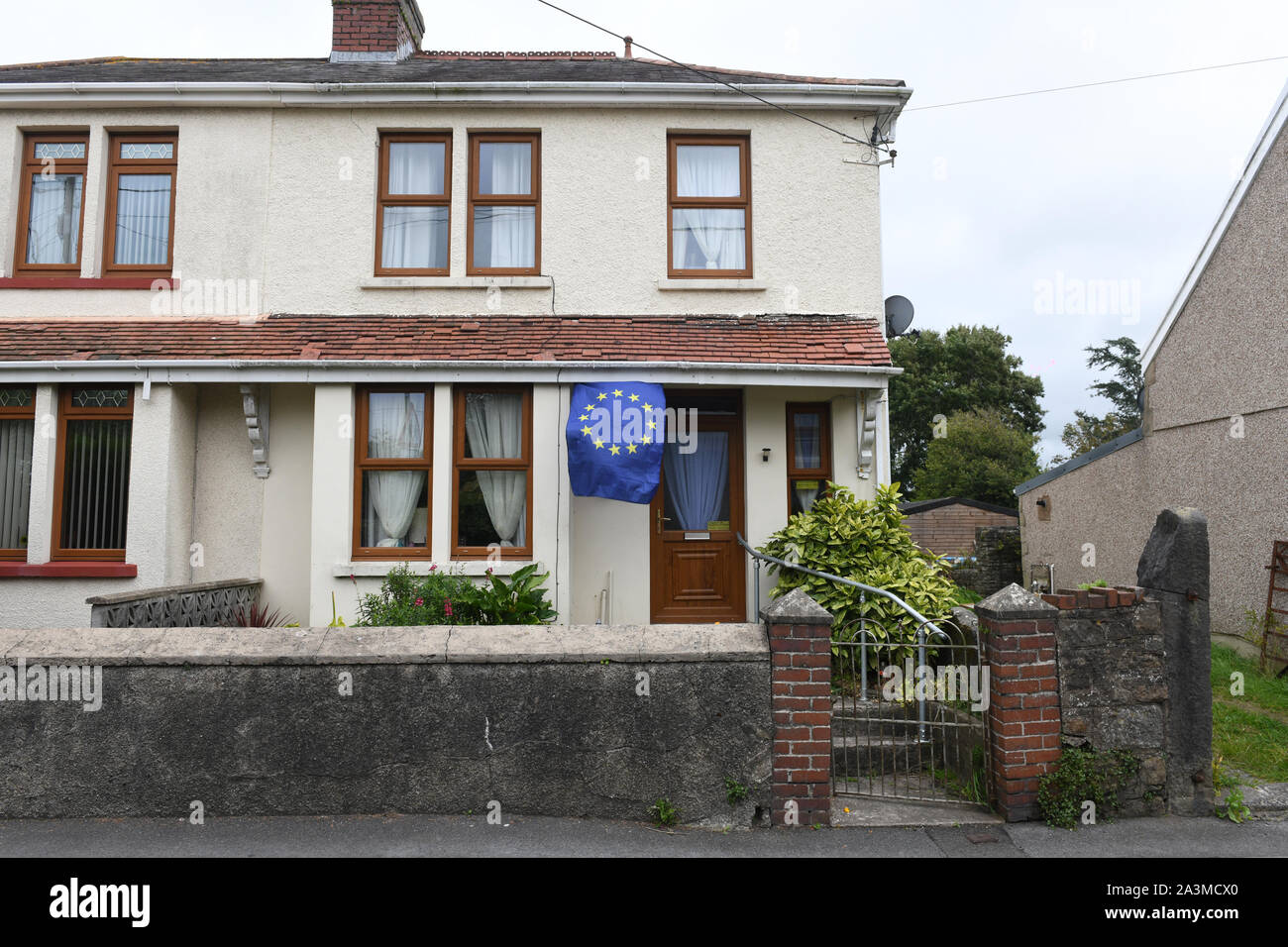 Une Union européenne drapeau flotte à l'extérieur d'une habitation jumelée maison à Kidwell, Pays de Galles, Royaume-Uni, pendant la crise Brexit. Banque D'Images