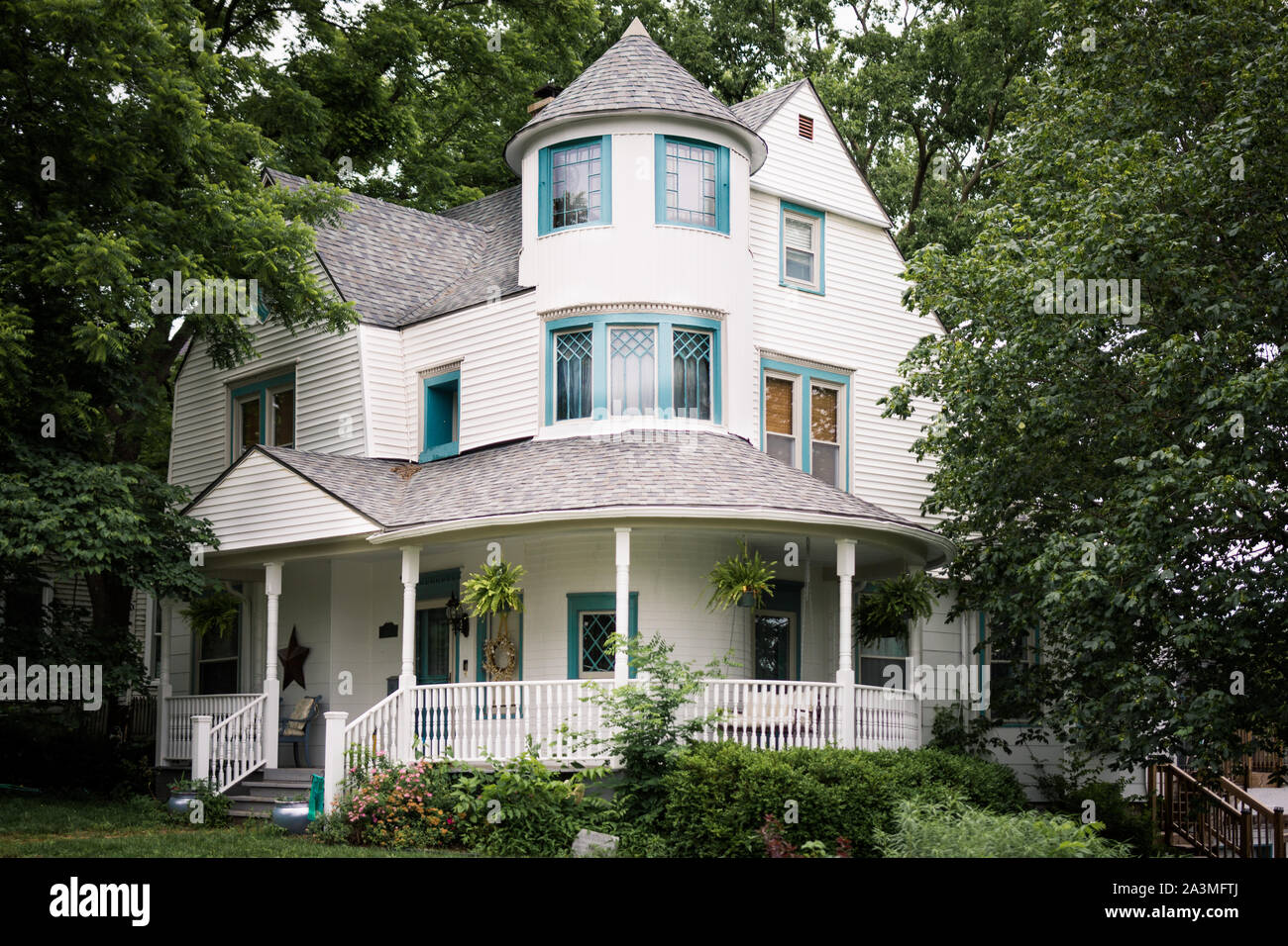 Trois étages élégant avec grand porche enveloppant entouré par de grands arbres Banque D'Images