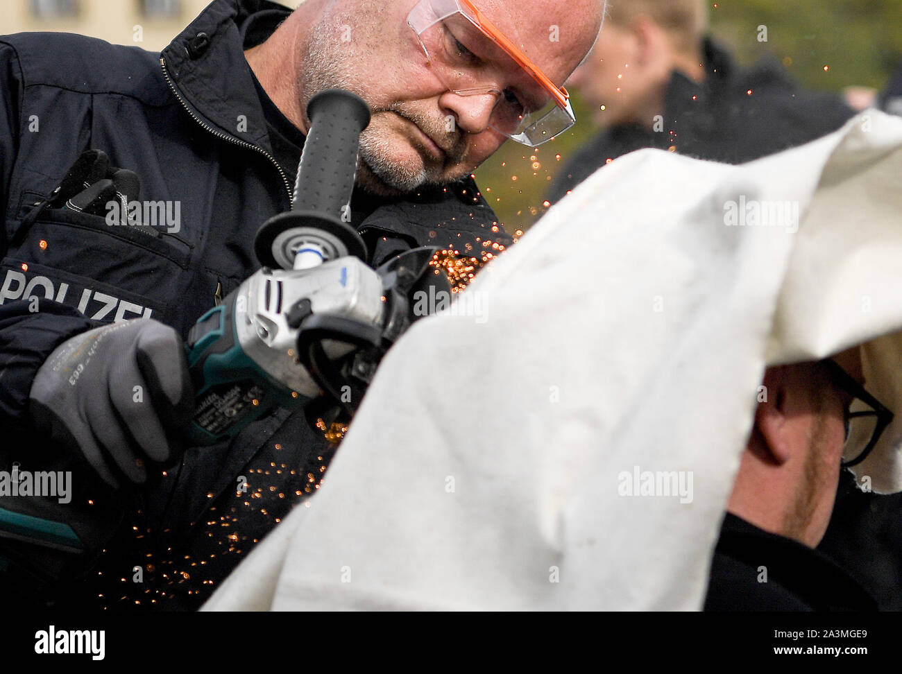 Berlin, Allemagne. 09Th Oct, 2019. Un policier ouvre un vélo de verrouillage de militants liés au mouvement de rébellion 'extinction' avec une meuleuse d'angle sur le Mühlendamm au pont Mühlendamm. Credit : Britta Pedersen/dpa-Zentralbild/dpa/Alamy Live News Banque D'Images
