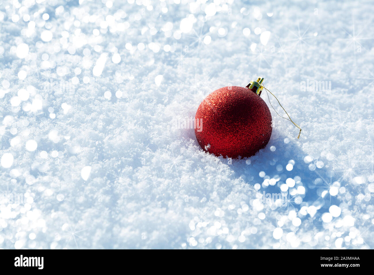 Red Ball jouet avec des lumières sur la neige fond. Fêtes de Noël et du Nouvel An fête concept Banque D'Images