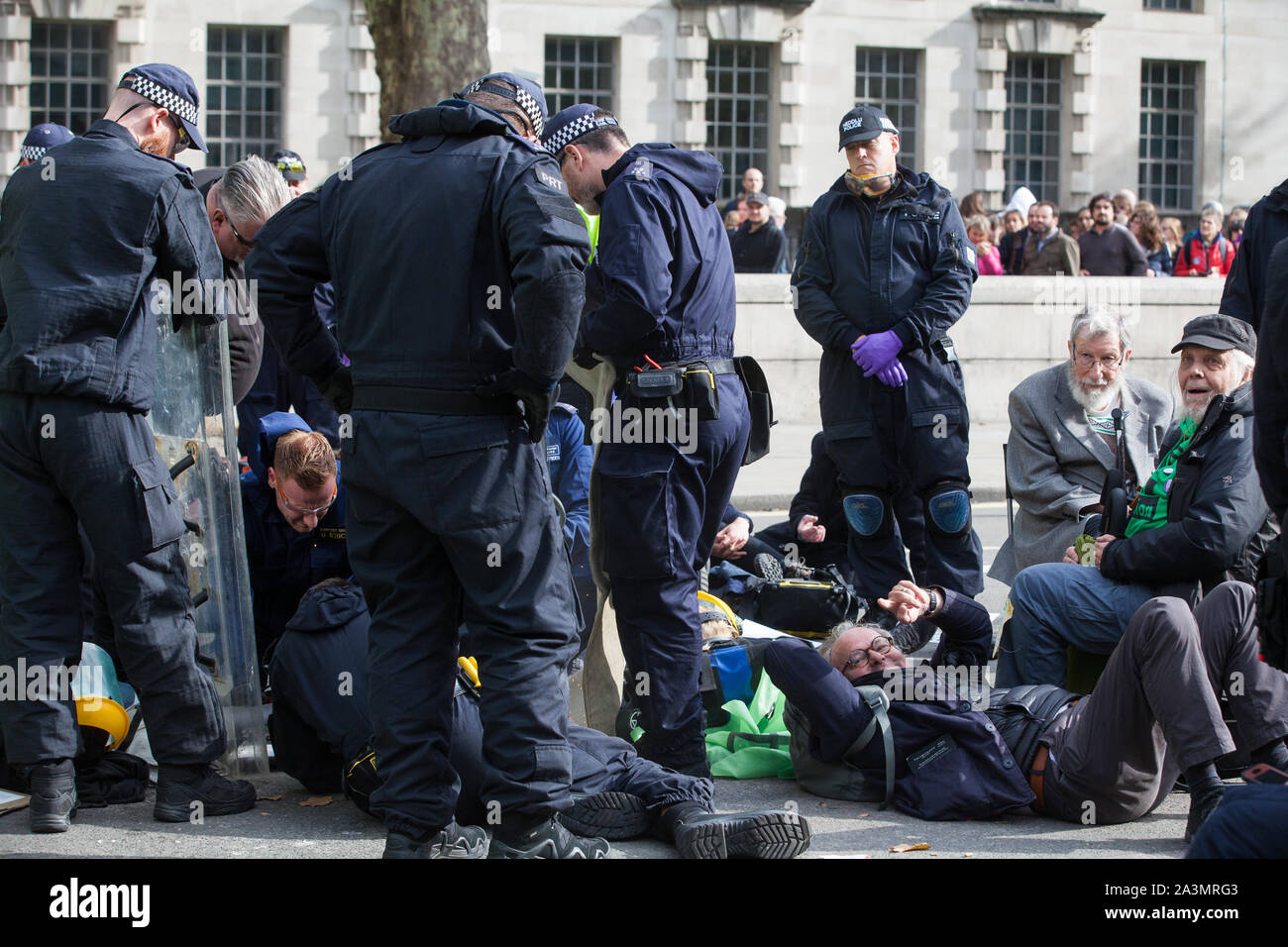 Londres, Royaume-Uni. 9 octobre, 2019. John, 91 ans, et David, un grand-père, les deux activistes du climat de l'Extinction, rébellion, attendre d'être arrêté par des policiers à l'aide de l'article 14 de la Loi sur l'ordre public de 1986 après le blocage Whitehall le troisième jour de manifestations internationales d'exiger une rébellion Déclaration gouvernementale d'un climat et d'urgence écologique, un engagement à enrayer la perte de biodiversité et la consommation énergétique nette zéro émissions de carbone en 2025 et pour le gouvernement de créer et d'être entraîné par les décisions d'une assemblée de citoyens sur le climat et la justice écologique. Credit : Mark Kerrison/Alamy Live News Banque D'Images