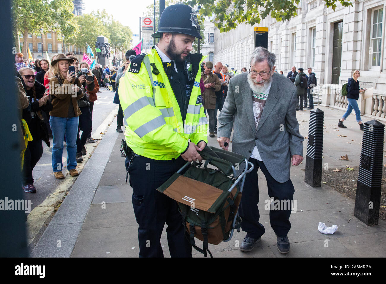 Londres, Royaume-Uni. 9 octobre, 2019. John Lynes, 91 ans, activiste climatique de l'extinction, la rébellion est arrêté par des policiers à l'aide de l'article 14 de la Loi sur l'ordre public de 1986 après le blocage Whitehall le troisième jour de manifestations internationales d'exiger une rébellion Déclaration gouvernementale d'un climat et d'urgence écologique, un engagement à enrayer la perte de biodiversité et la consommation énergétique nette zéro émissions de carbone en 2025 et pour le gouvernement de créer et d'être entraîné par les décisions d'une assemblée de citoyens sur le climat et la justice écologique. Credit : Mark Kerrison/Alamy Live News Banque D'Images