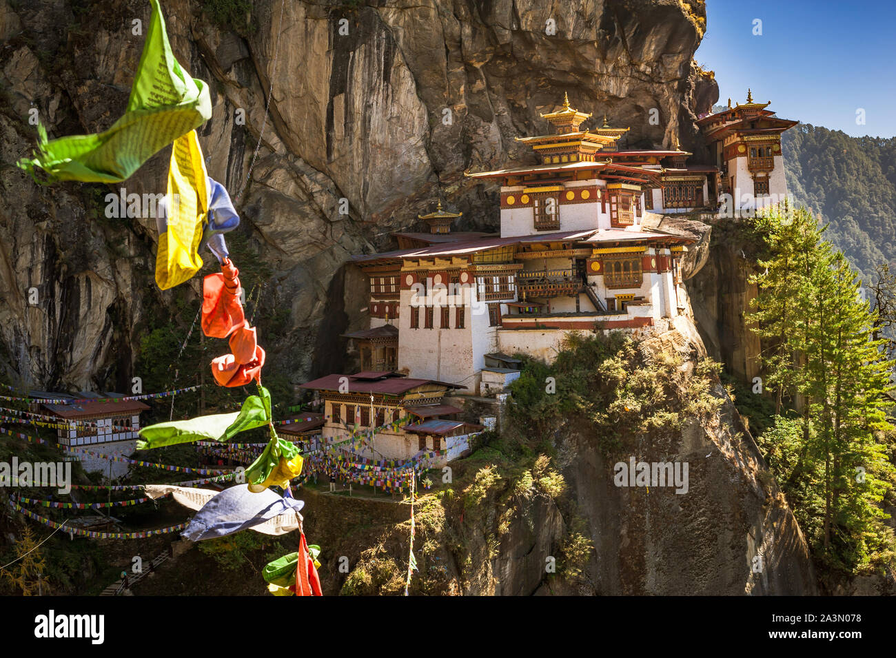 Drapeaux de prière volant à Paro Taktsang. Connu comme le nid du tigre, c'est un site sacré du bouddhisme au Bhoutan. Banque D'Images
