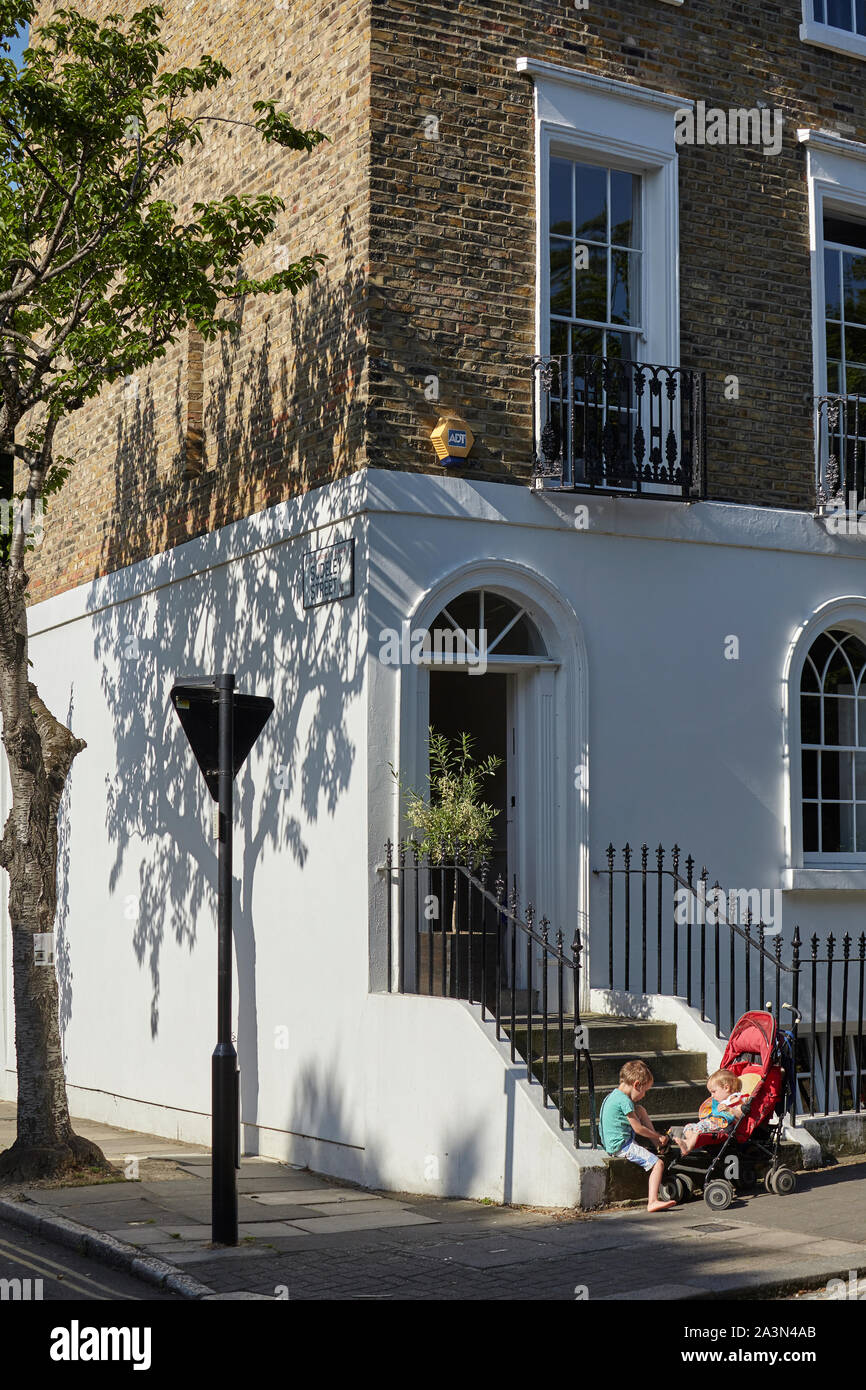Les enfants sur les marches d'une maison à Islington, Londres. Banque D'Images