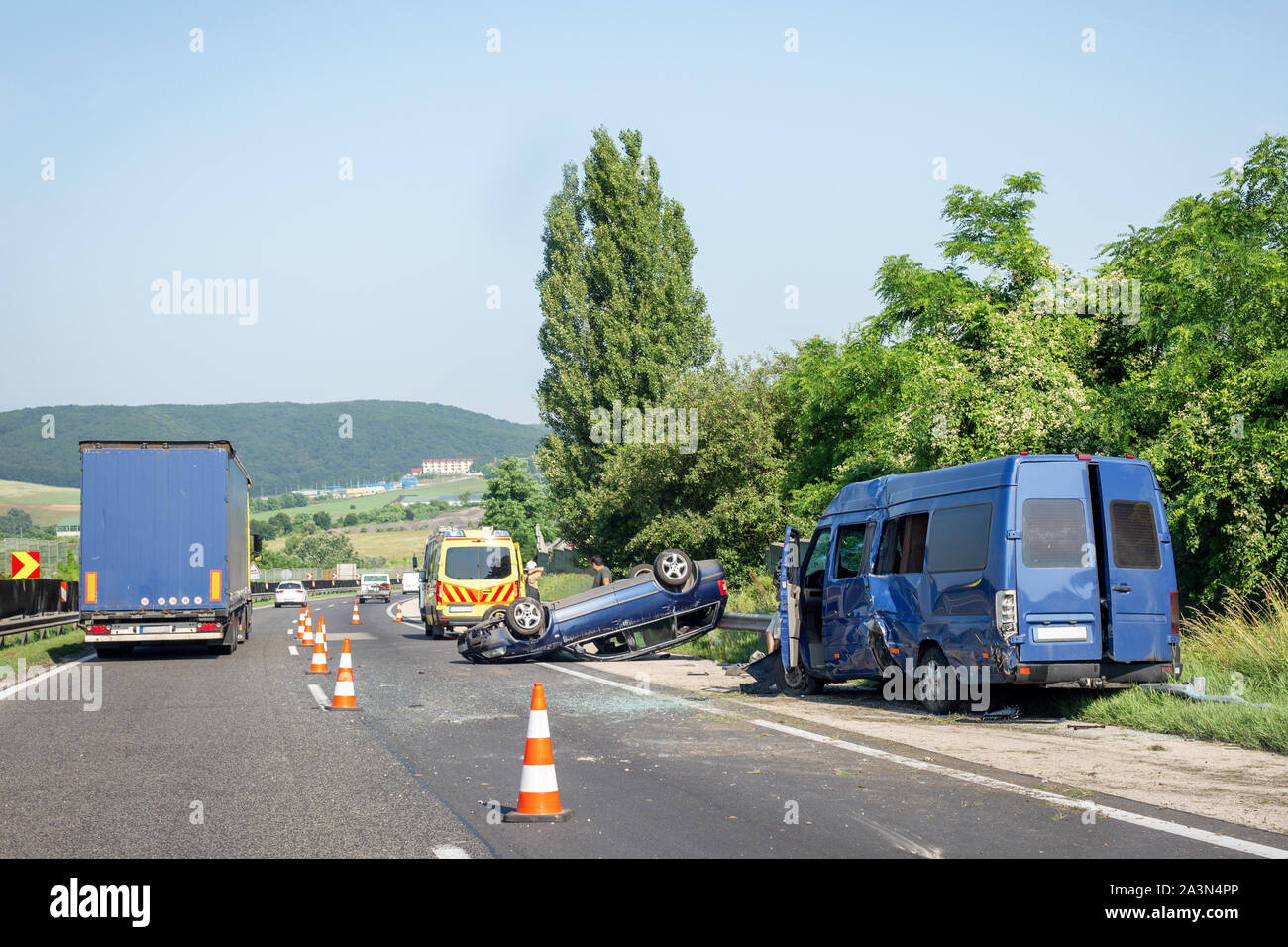 Accident de voiture survenue sur l'autoroute. Minibus bleu endommagé après collision, a renversé et voiture voiture d'ambulance sur la route. Cônes de circulation au lieu de l'accident Banque D'Images