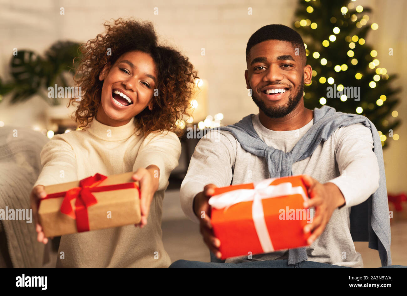 Black couple holding Christmas Gift boxes and smiling Banque D'Images