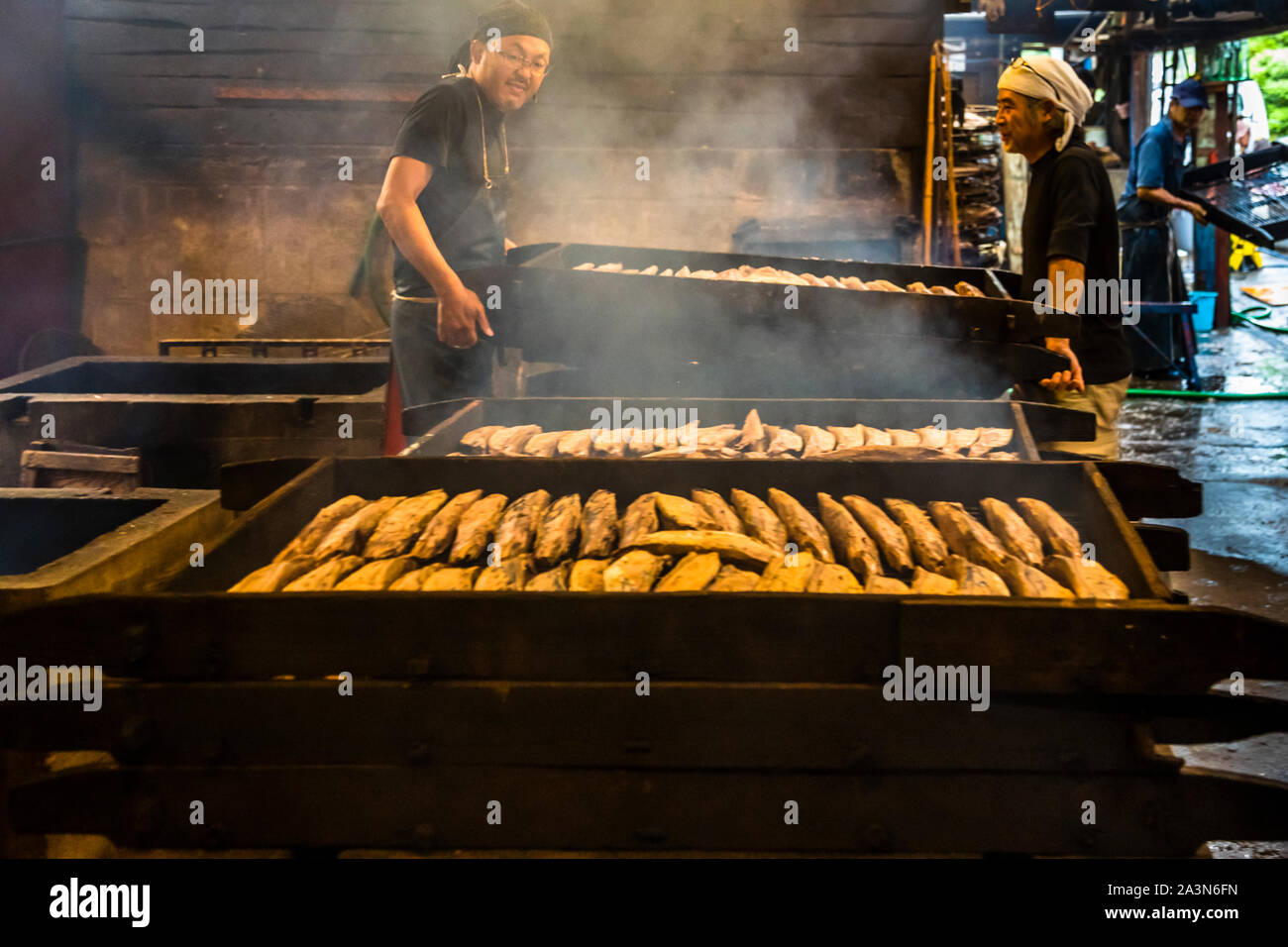 Fabricant de Katsuobushi de Yasuhisa Serizawa à Nishizu-Cho, Shizuoka, Japon. 'Baikan' - seul le bois dur comme le chêne est utilisé pour fumer. Au cours de ce premier processus de tabagisme, qui va tard dans la nuit, deux travailleurs protègent l'incendie pendant huit heures Banque D'Images