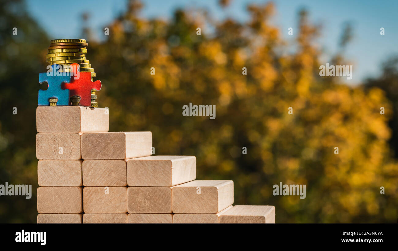 Concept d'équipe. La notion de victoire. Deux casse-tête sont au haut de l' escalier fait de blocs en bois avec fond ensoleillé automne floue Photo  Stock - Alamy
