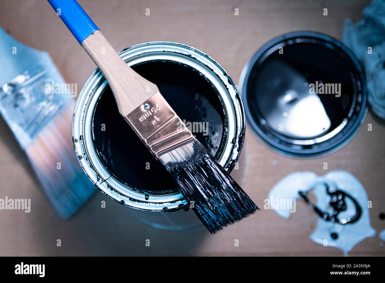 pinceau de 1 pouce reposant sur une boîte ouverte de peinture émaillée Banque D'Images