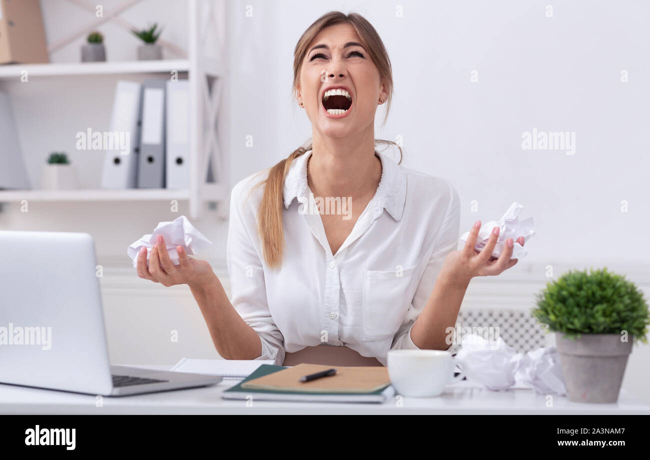Angry Businesswoman criant de l'enfoncement de papier Banque D'Images