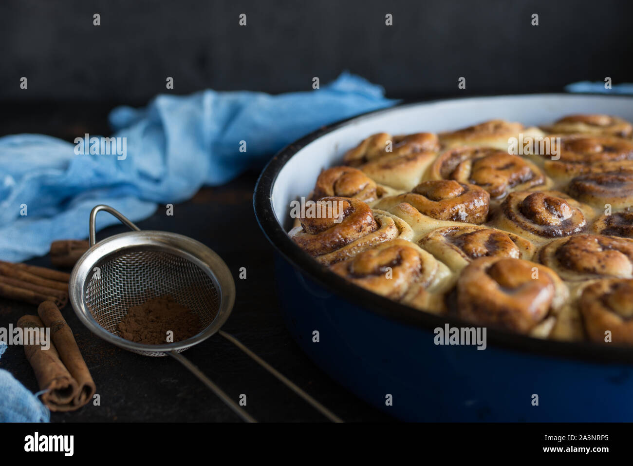 Tarte à la cannelle avec du sirop de sucre dans la casserole de vintage sur fond noir Banque D'Images