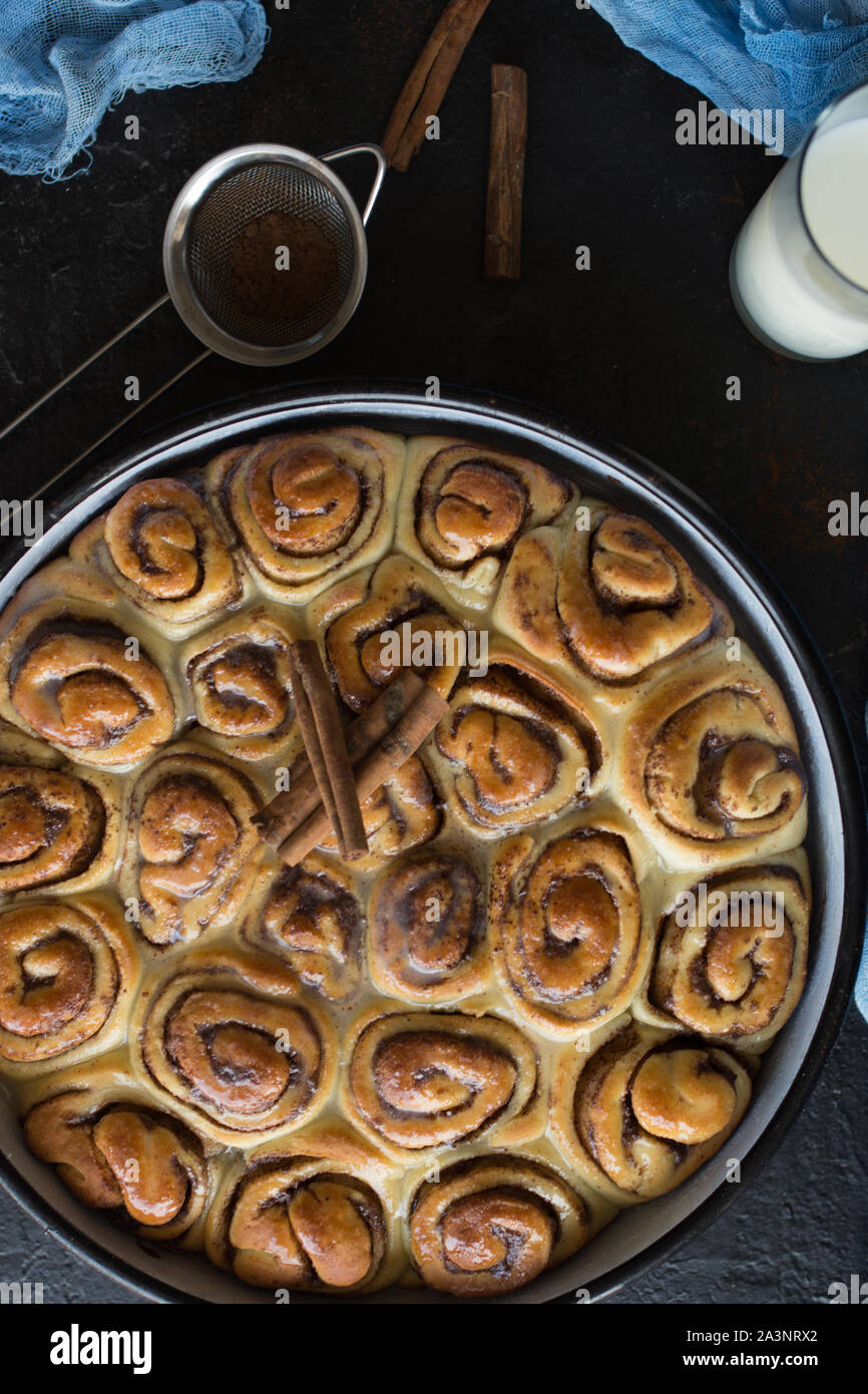Tarte à la cannelle avec du sirop de sucre dans la casserole de vintage sur fond noir Banque D'Images