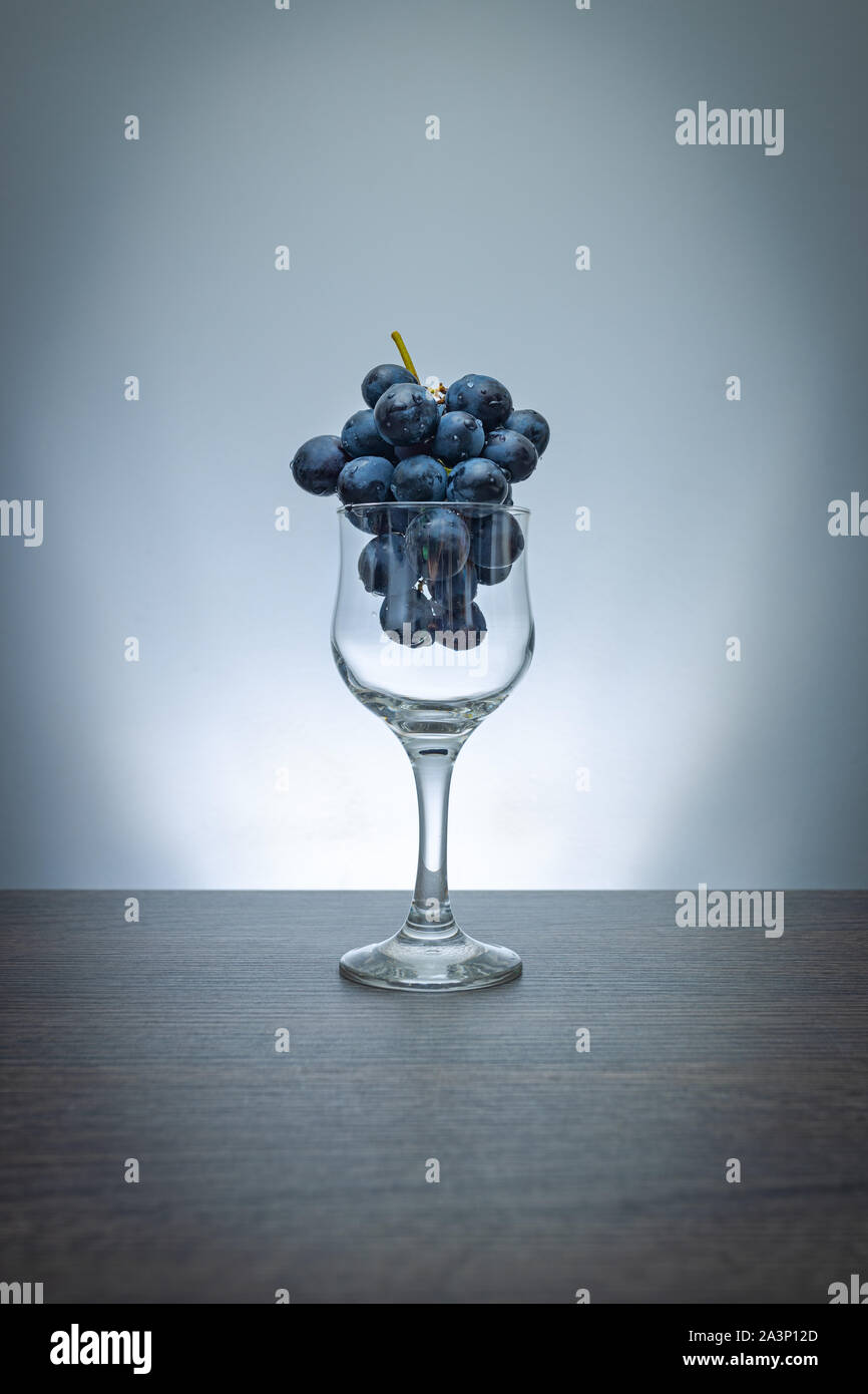 Idée conceptuelle de raisins dans le verre de vin comme matières premières au lieu de produit final Banque D'Images