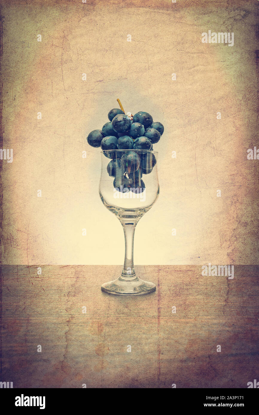 Idée conceptuelle de raisins dans le verre de vin comme matières premières au lieu de produit final à l'aide d'un filtre vintage Banque D'Images