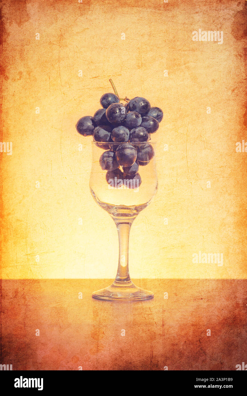 Idée conceptuelle de raisins dans le verre de vin comme matières premières au lieu de produit final à l'aide du filtre rétro Banque D'Images