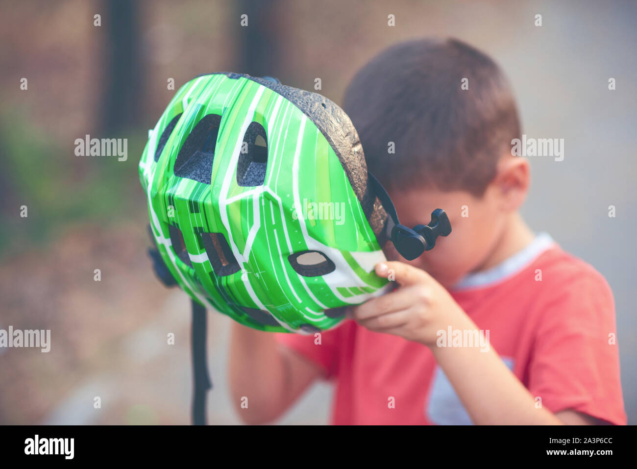 Un garçon portant un casque pour faire du vélo Banque D'Images