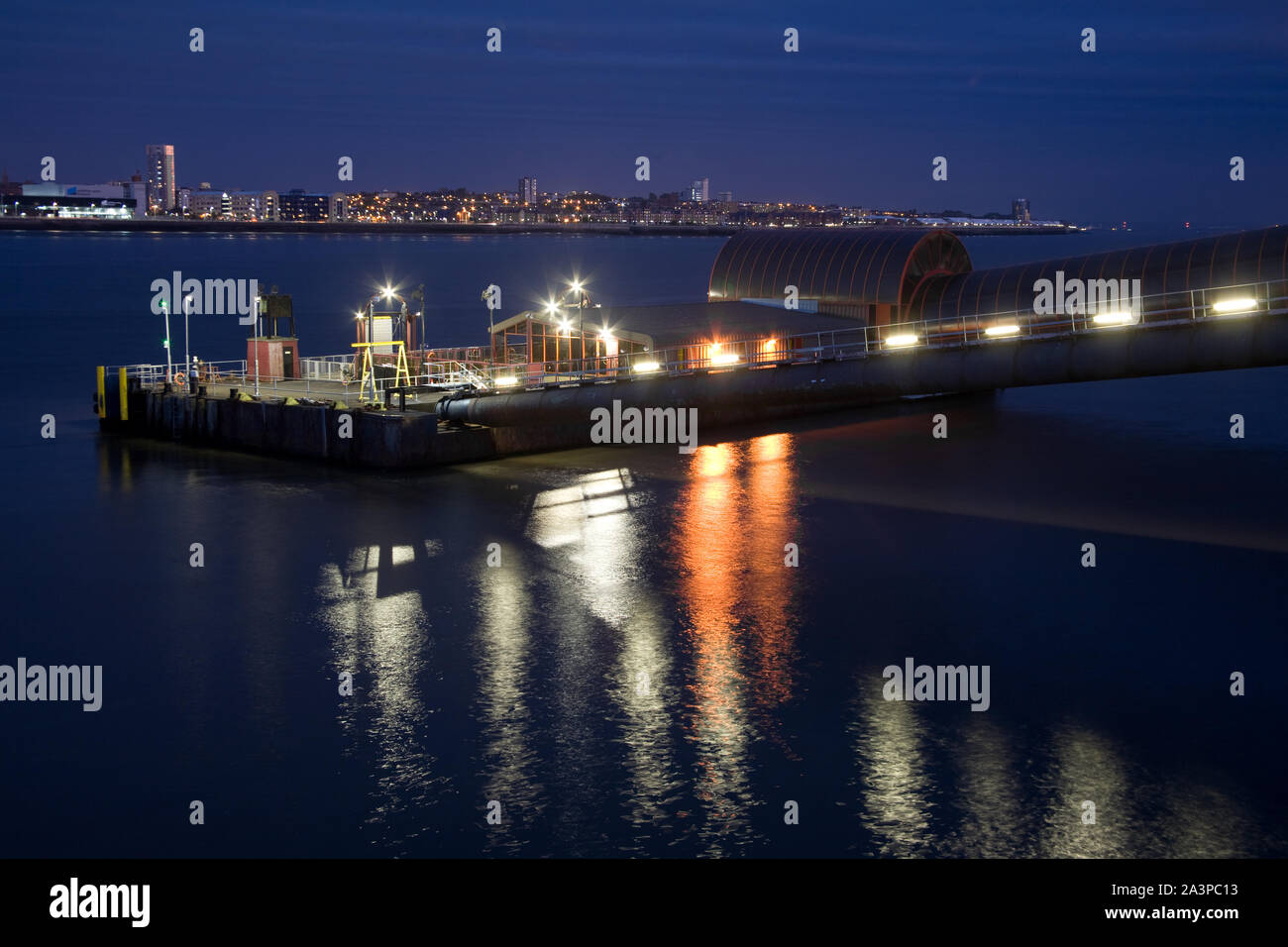 Le terminal de ferry de Woodside à Birkenhead éclairés la nuit, avec l'horizon de la ville de Liverpool sur la Rivière Mersey Banque D'Images