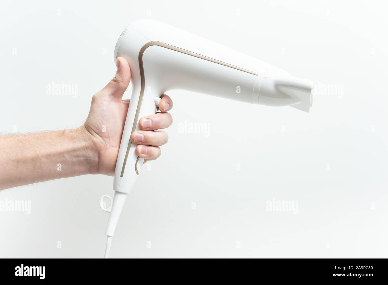 La main humaine tient un sèche-cheveux sur un fond blanc. Banque D'Images