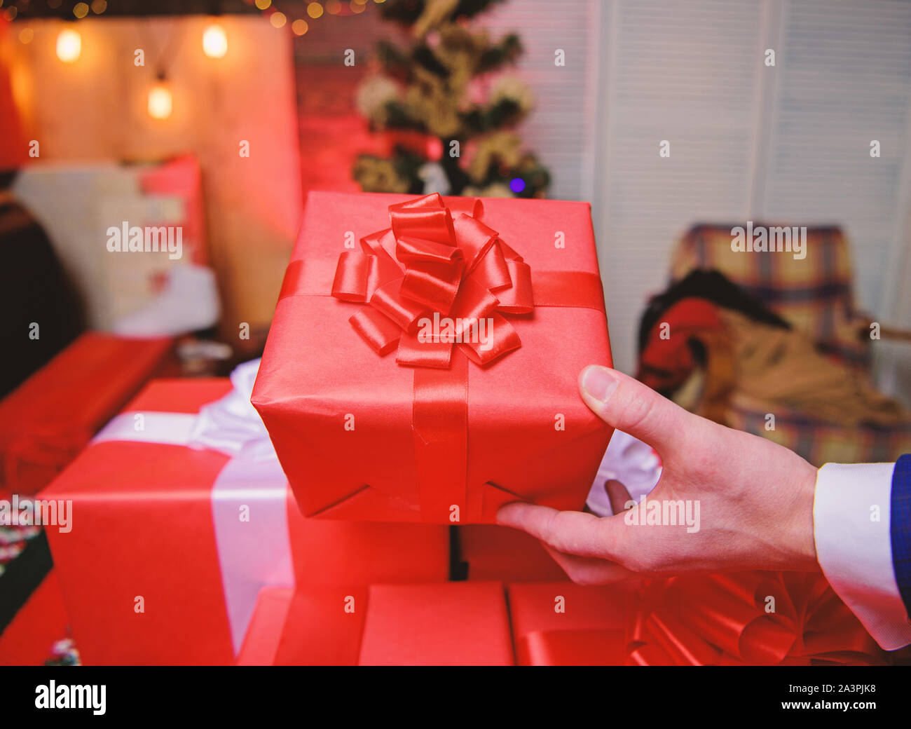 Cadeaux concept. Moments magiques. Préparer des cadeaux surprises pour la famille et les amis. Se préparer à Noël et nouvel an. Boîtes cadeaux avec big ribbon bow close up. Les cadeaux emballés rouge ou présente. Banque D'Images