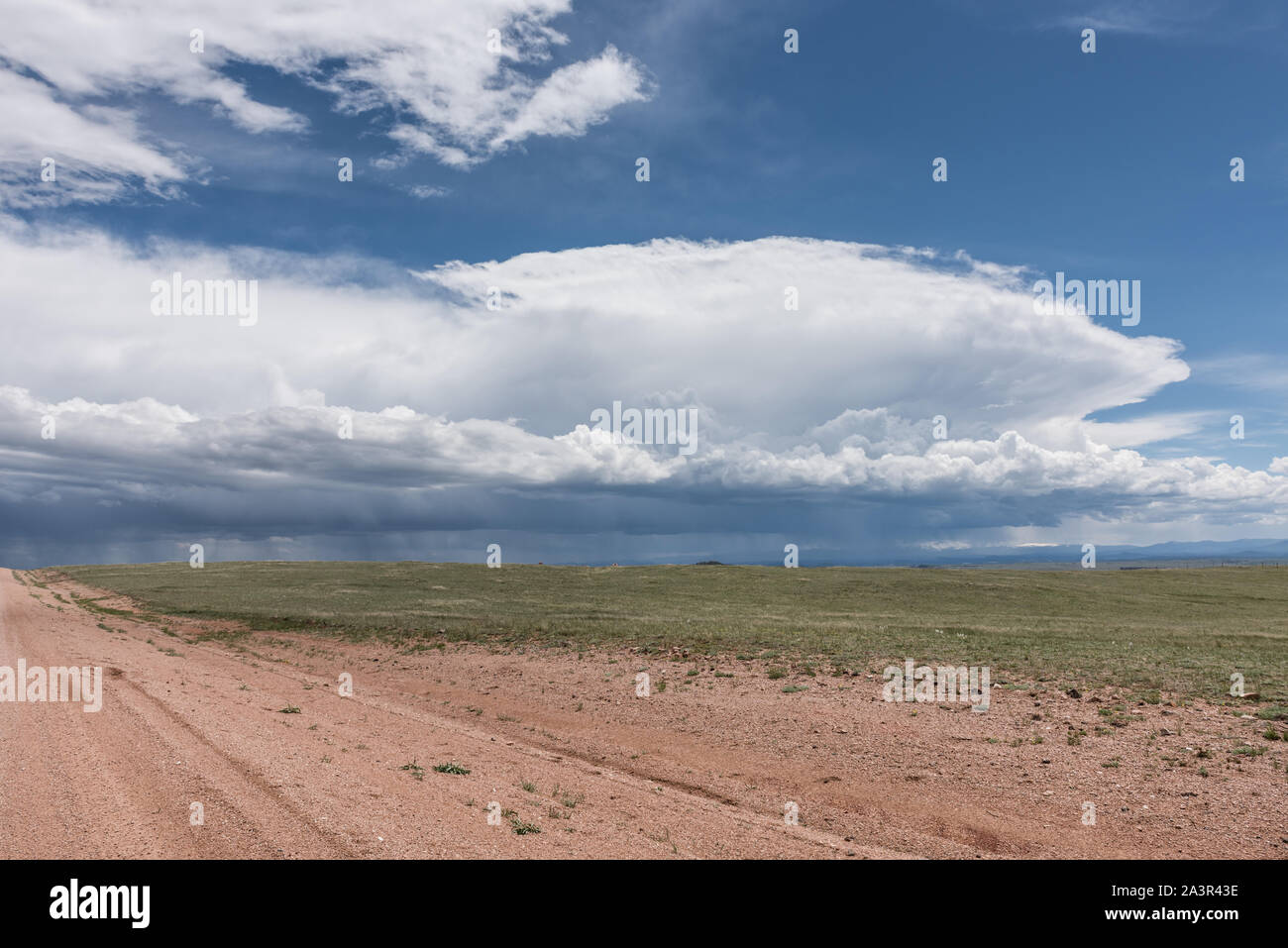 Nuages de tempête de recueillir sur une longue route de terre dans le comté d'Albany, Wyoming Banque D'Images