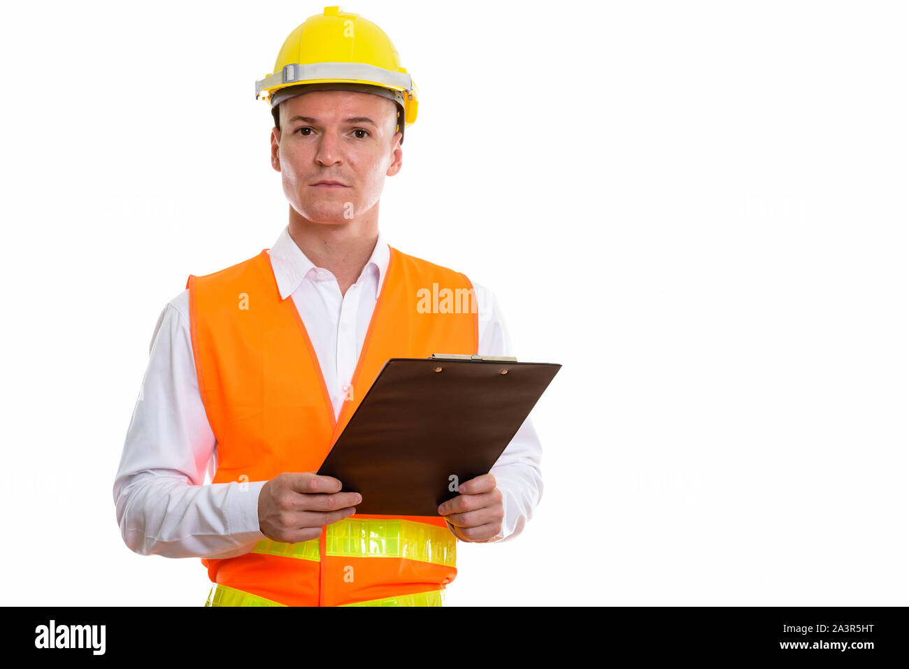 Studio shot of young handsome man construction worker holding cl Banque D'Images