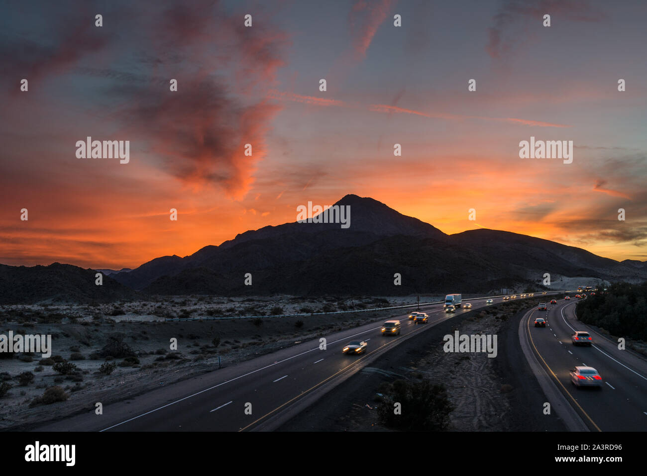 Coucher de soleil sur la montagne et la soude Barstow freeway (autoroute 15) à l'est de Baker, en Californie Banque D'Images