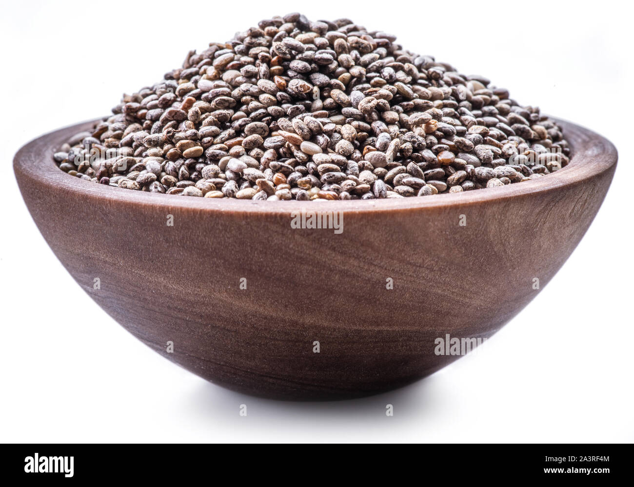 Les graines de Chia dans bol en bois isolé sur fond blanc. Banque D'Images