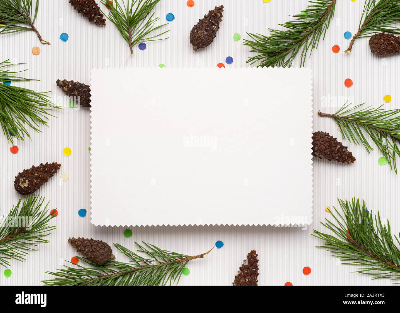 Joyeux Noël et bonne année l'arrière-plan. Note blanche feuille de papier. Décor de branches de pins, de cônes et de confettis de fête Banque D'Images