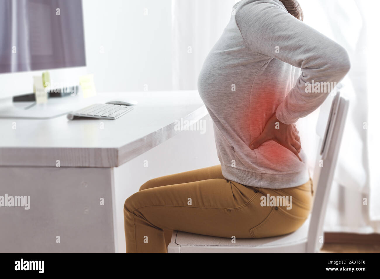 Douleur rénale. Douleur dans le dos d'une femme de travail à l'ordinateur. Banque D'Images