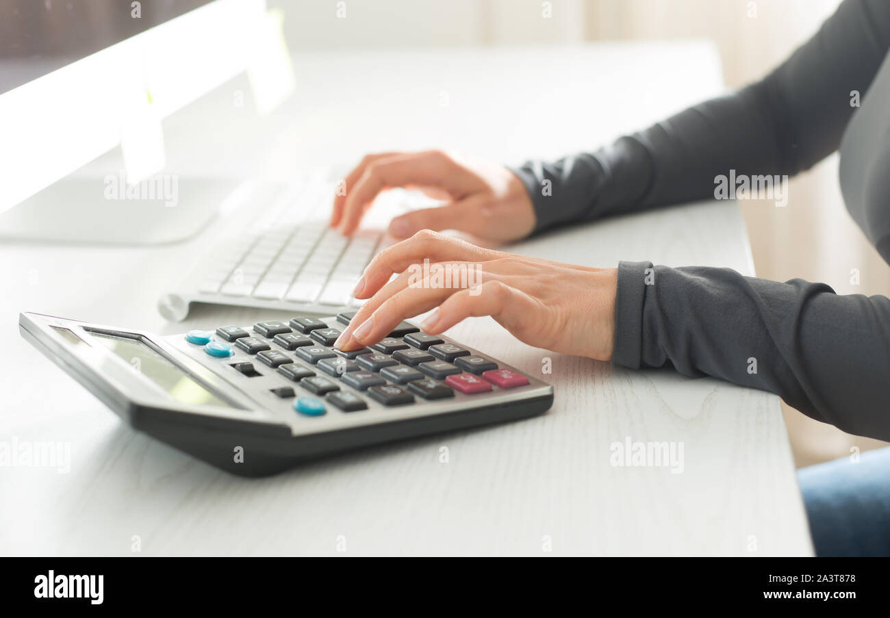 Le comptable travaille sur une calculatrice. Le financier rédige une déclaration de revenus. L'homme d'affaires sur le lieu de travail. Banque D'Images