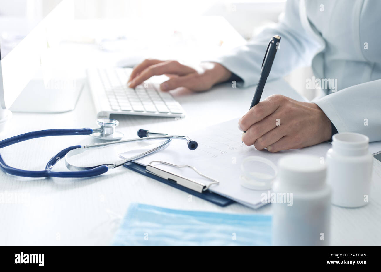 Femme médecin rédige un rapport médical dans le bureau de la clinique. Banque D'Images