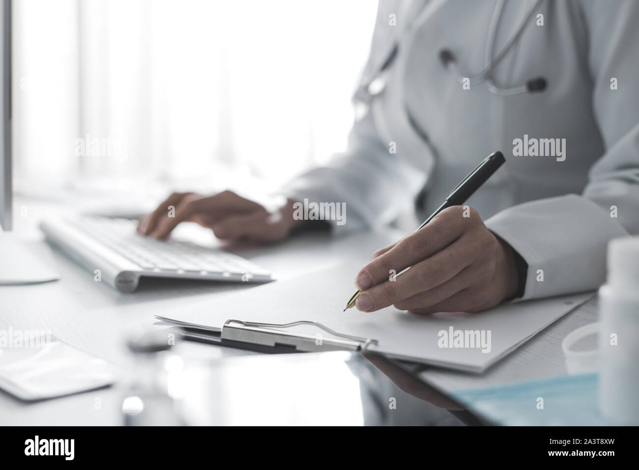 Femme médecin rédige un rapport médical dans le bureau de la clinique. Banque D'Images