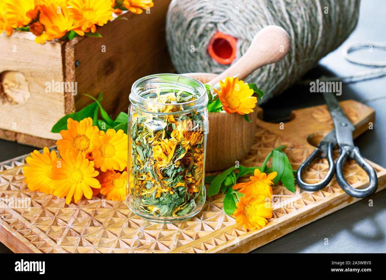 De fines herbes Calendula matériel : un pot avec marigold sec, un mortier avec bouquet de fleurs fraîches, des ciseaux et fils de lin et une boîte de médicaments ma Banque D'Images