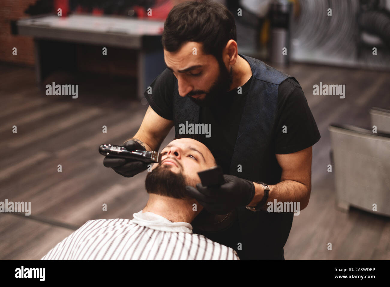 Le rasage de la barbe dans un salon de coiffure avec un dangereux rasoir.  Salon de coiffure pour les soins de la barbe. Le séchage, couper, couper la  barbe. Selective focus Photo