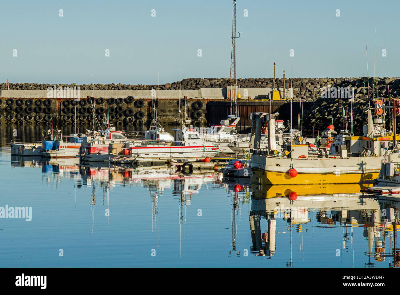 Olafsvik Harbour Snaefellsnes Peninsula West Iceland montrant un port très calme avec des bateaux amarrés ainsi que leurs réflexions. Banque D'Images