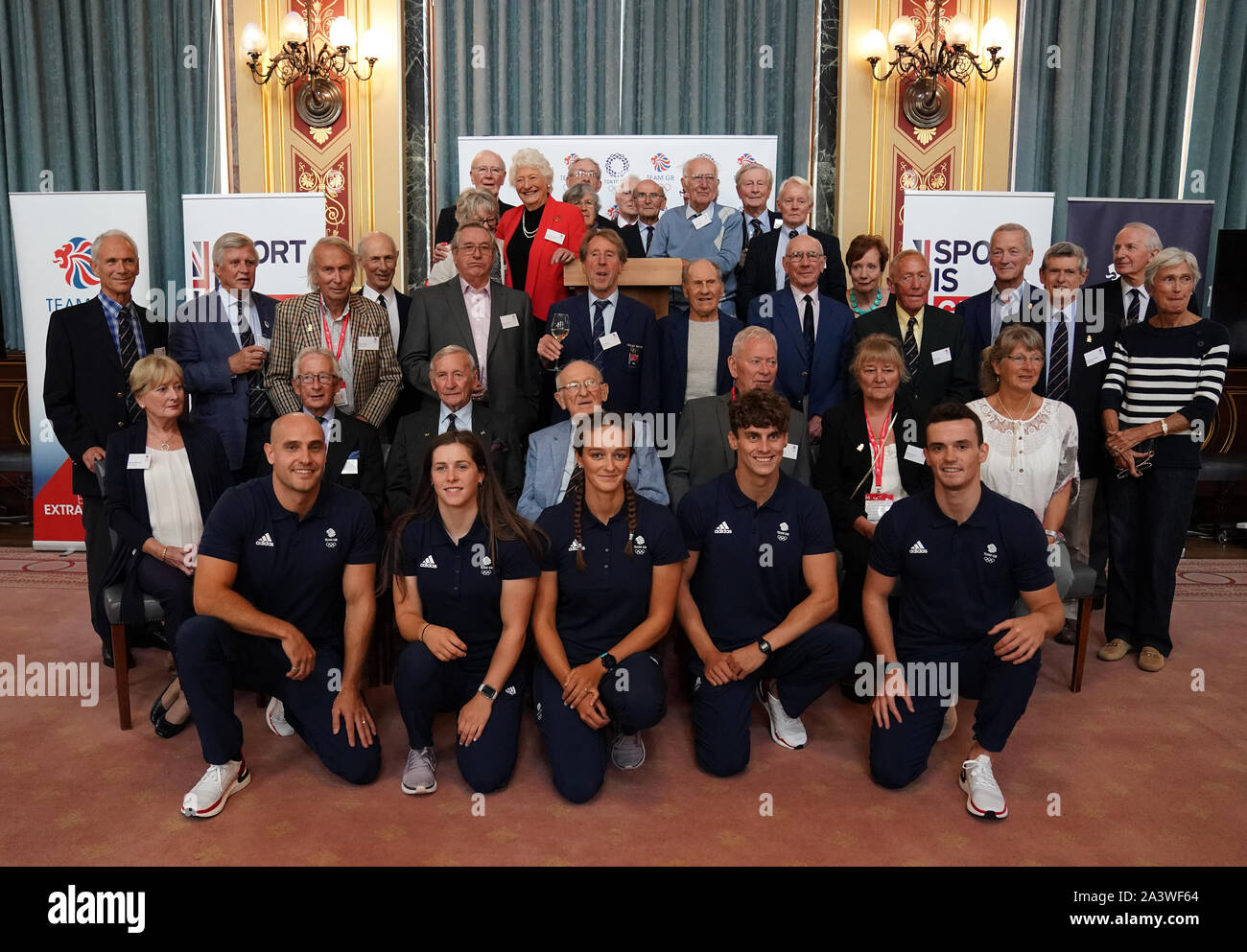 Les olympiens de 1964 avec la nouvelle équipe GO Olympiens (rangée avant : de gauche à droite) Liam Heath, Kimberley Woods, Mallory Franklin, Adam Bradley Burgess et Forbes-Cryans célébrer le 55e anniversaire de la cérémonie d'ouverture des Jeux Olympiques de Tokyo 1964 au ministère des Affaires étrangères et du Commonwealth, Londres. Banque D'Images