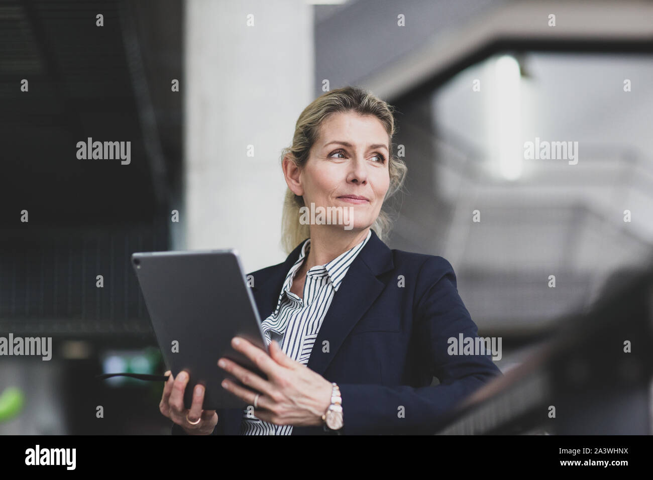 Senior female business executive using digital tablet in a Corporate Office Banque D'Images