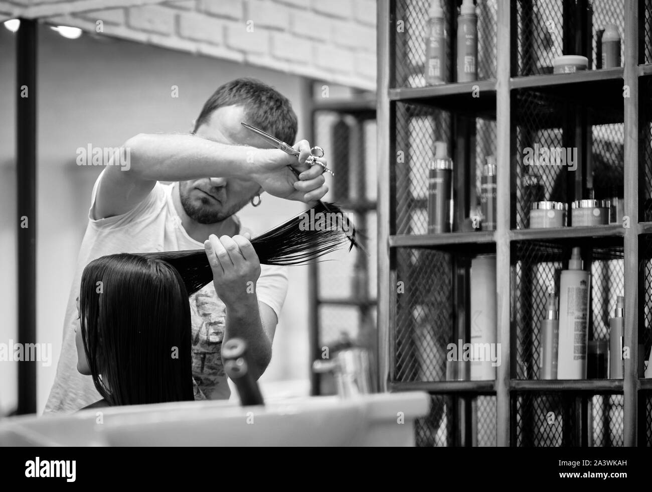Moscou, Russie - 10 Oct 2019 : coiffeur professionnel travaillant avec le client dans le salon. Coiffeur homme et femme client en beauté. BW Black & White Banque D'Images