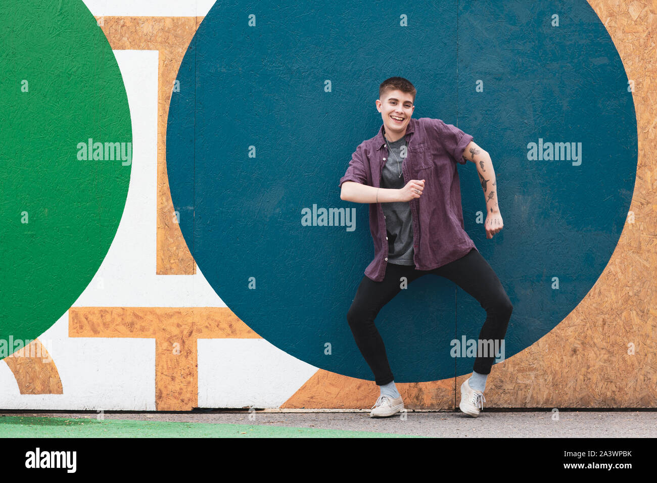 Portrait de jeunes adultes en danse par mur bleu vif Banque D'Images