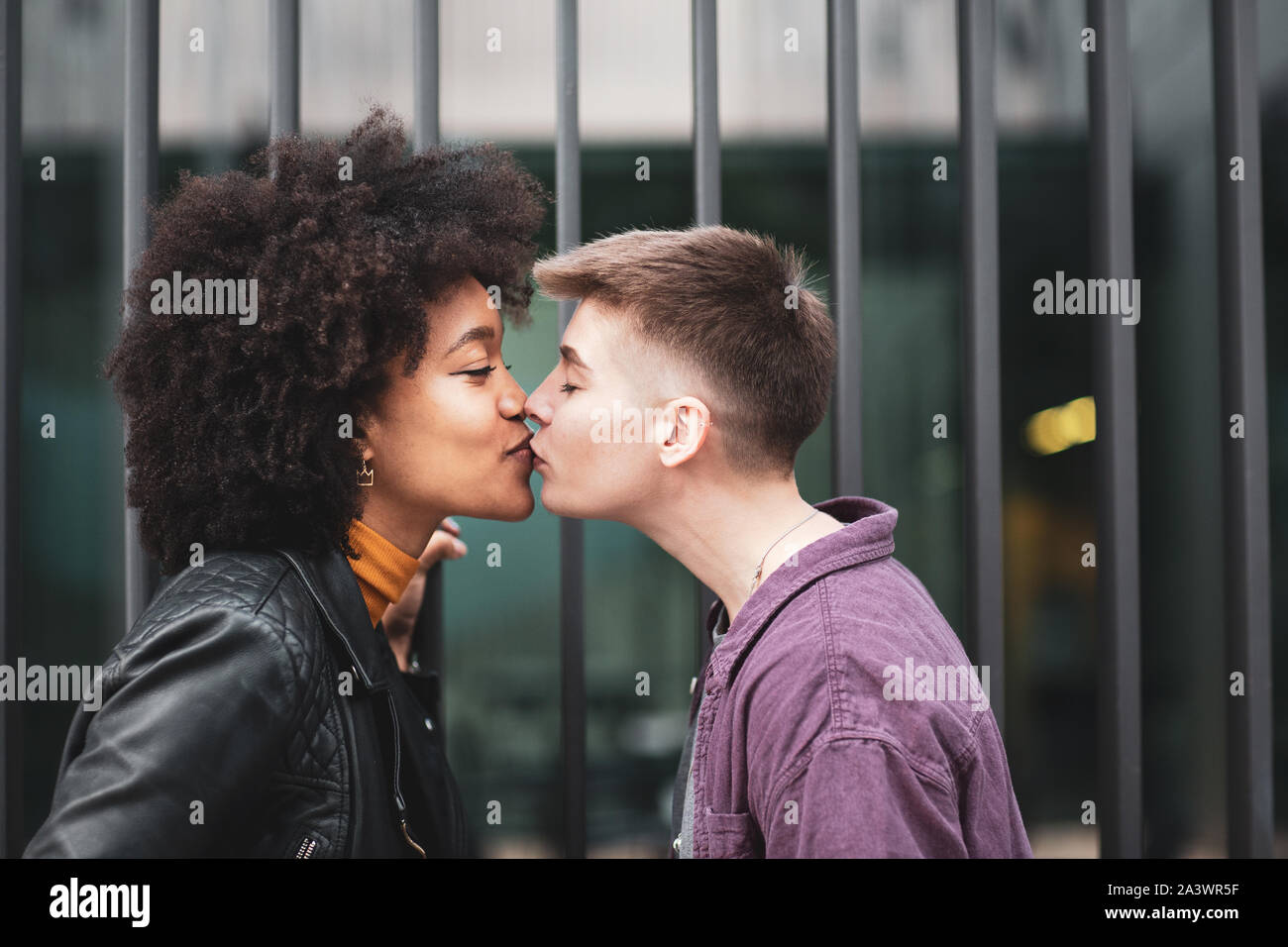 Young adult lesbian couple kissing outdoors in city Banque D'Images