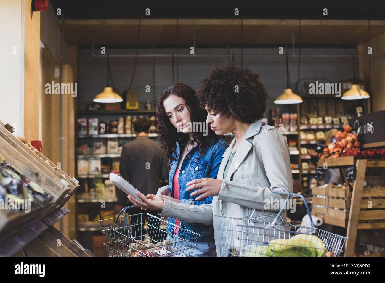 Les jeunes femelles adultes food shopping dans un magasin d'alimentation Banque D'Images