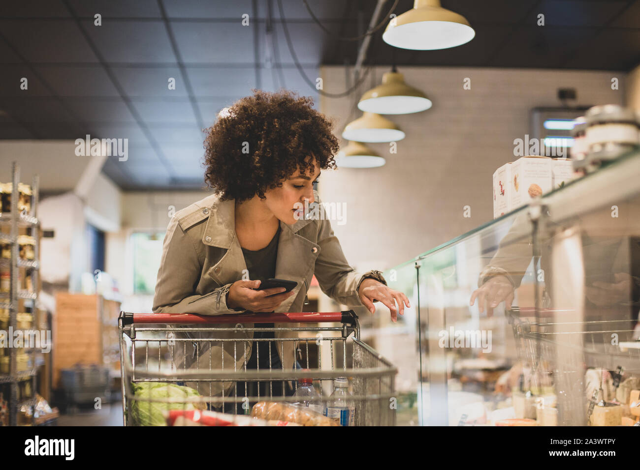 African American shopper à comptoir de charcuterie dans une épicerie Banque D'Images
