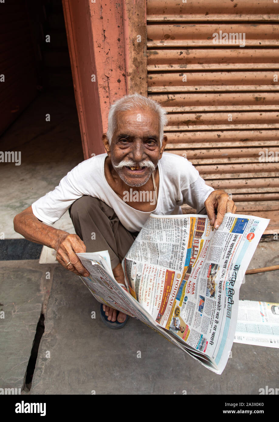 Smiling indian man lire le journal dans la rue, du Rajasthan, Jaipur, Inde Banque D'Images