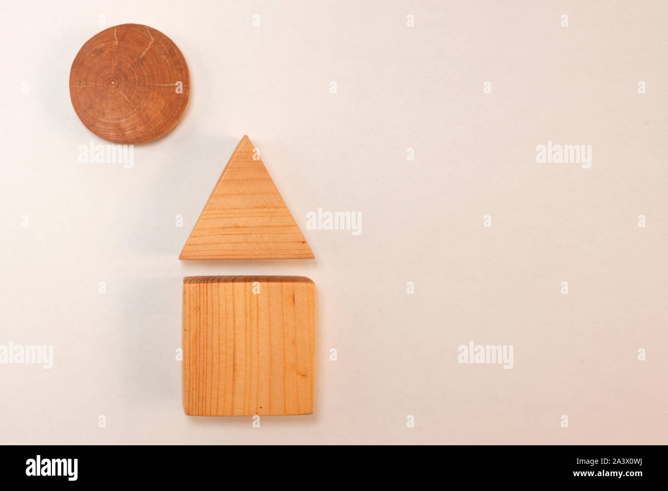 Maison en bois et le soleil au-dessus avec des ombres sur fond blanc. Figures géométriques simples carré, triangle, cercle, comme concept de développement enfants jouet, con Banque D'Images