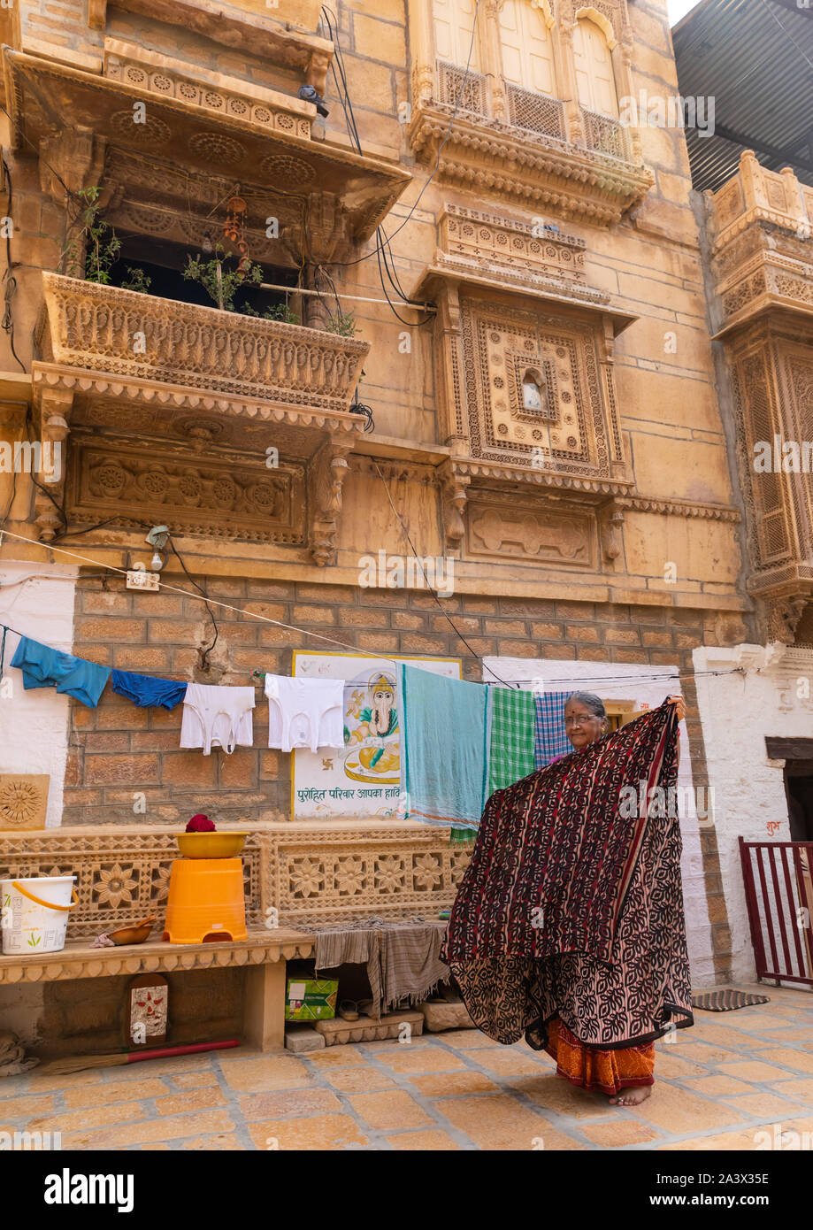 Femme indienne saris suspendus devant ses haveli, Rajasthan, Jaisalmer, Inde Banque D'Images