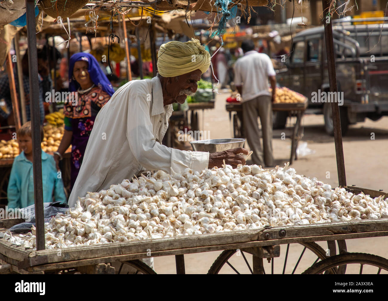 L'homme indien de la vente de l'ail dans un marché, le Rajasthan, Jaisalmer, Inde Banque D'Images